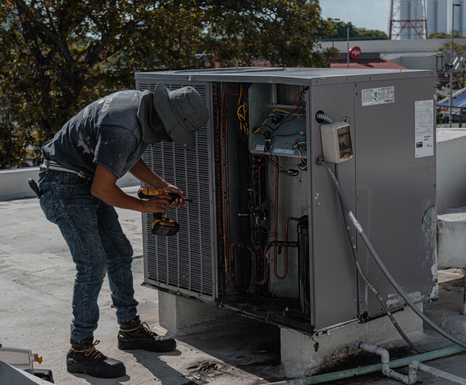 HVAC technician servicing an outdoor air conditioning unit