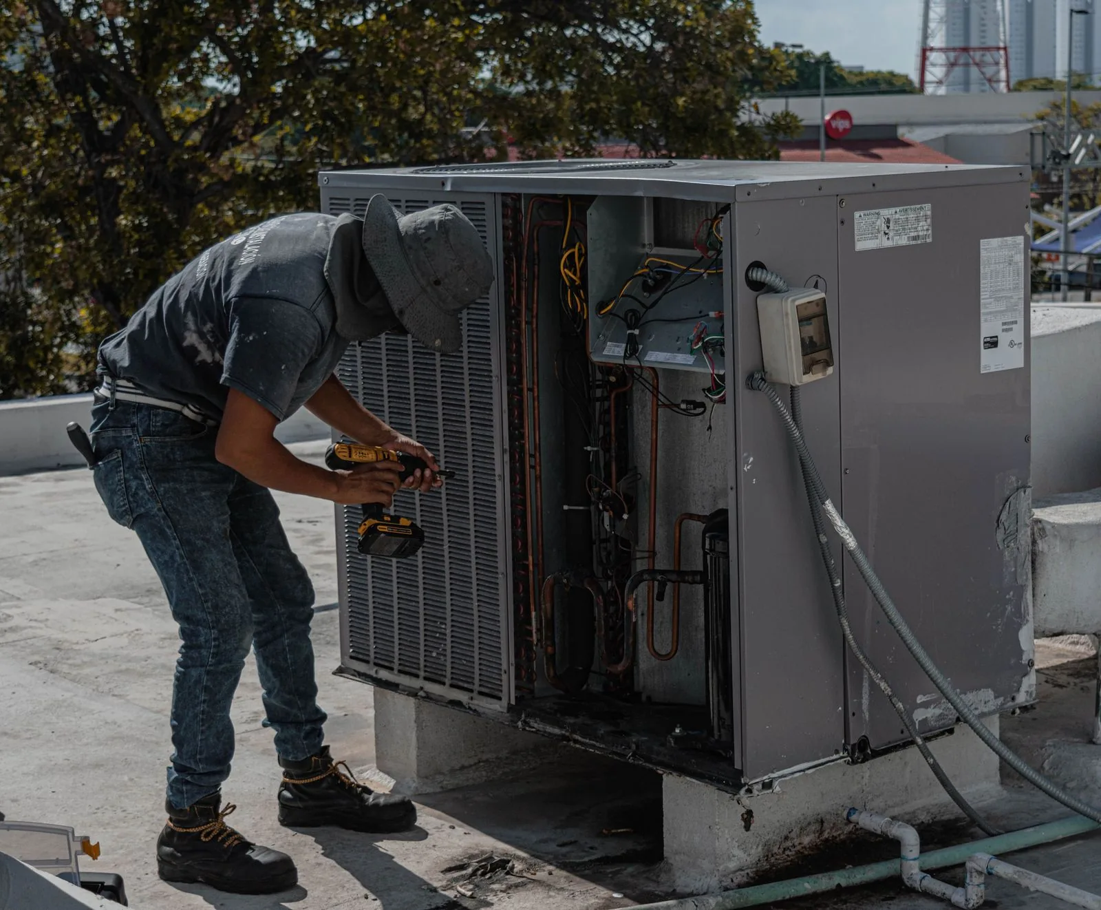 HVAC technician servicing an outdoor air conditioning unit