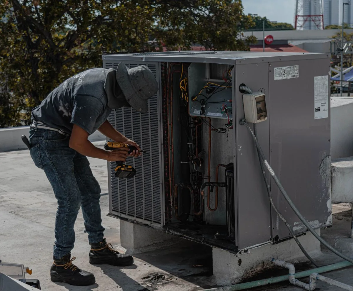 HVAC technician servicing a rooftop air conditioning unit