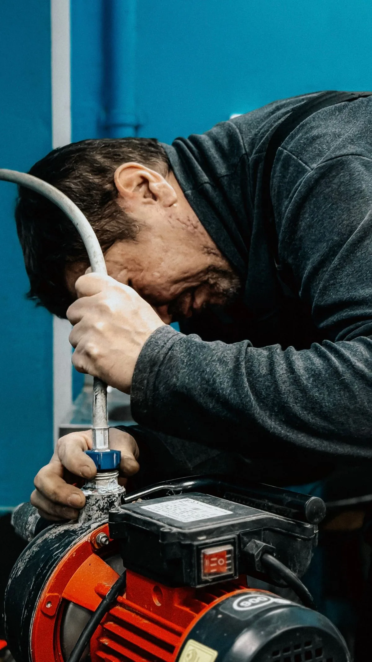 Plumber working under a sink with tools