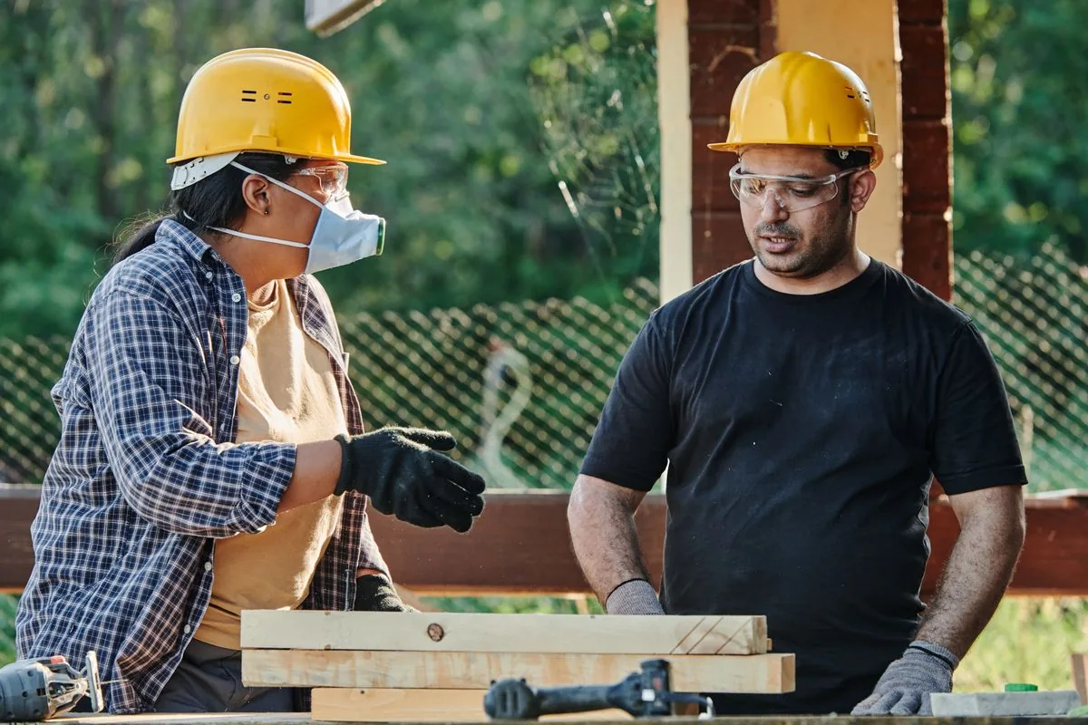 Construction workers discussing building plans at a job site