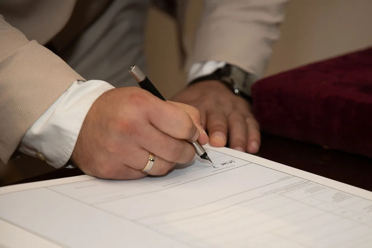 Hand signing an estimate document with a pen