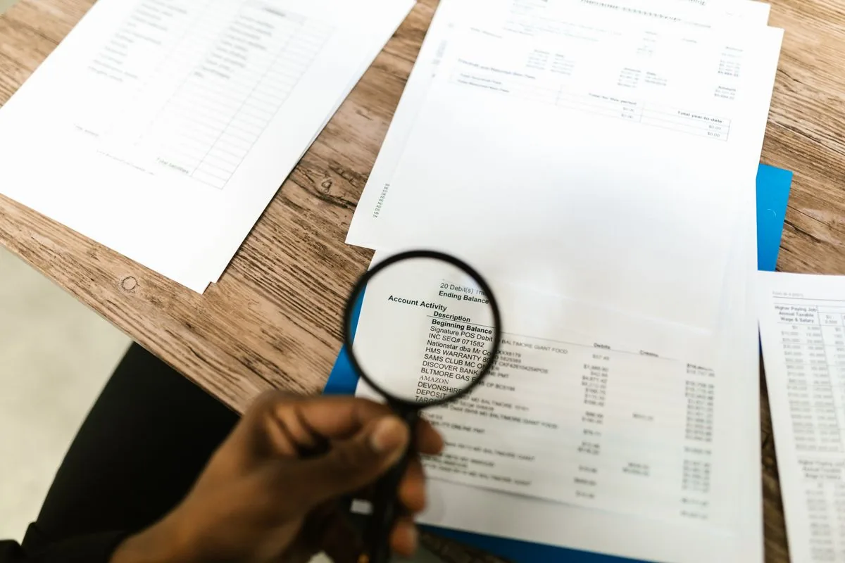 Contractor reviewing estimate paperwork with a magnifying glass at a desk