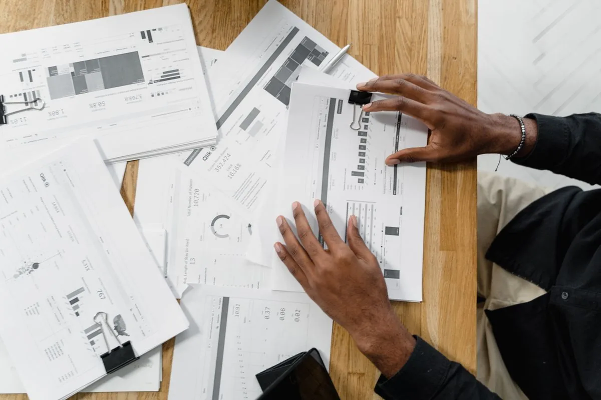 Contractor reviewing invoice paperwork and folders at a desk