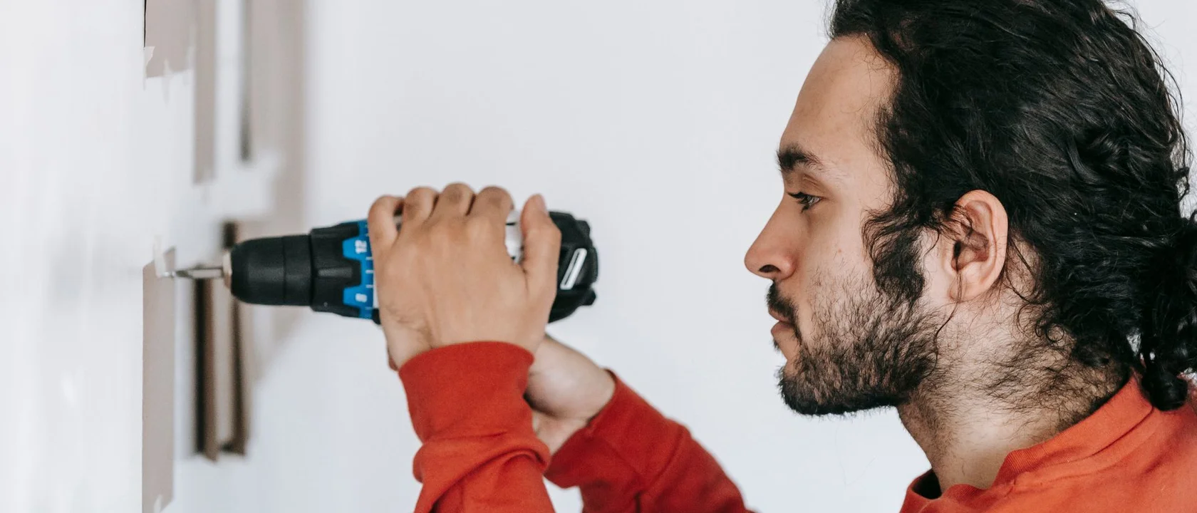 Handyman drilling into a wall during a home repair