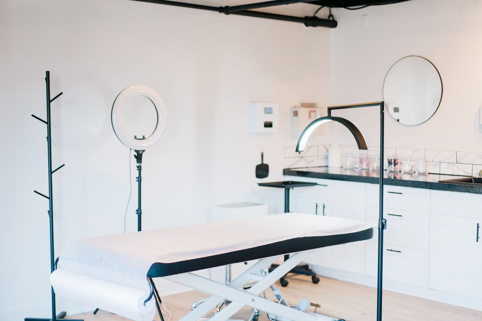 Bright, modern med-spa treatment room with treatment bed and studio lighting